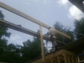 Carpenter setting a ridge beam over a new addition frame — Ice Dam Removal by Roofing Brothers in Humboldt