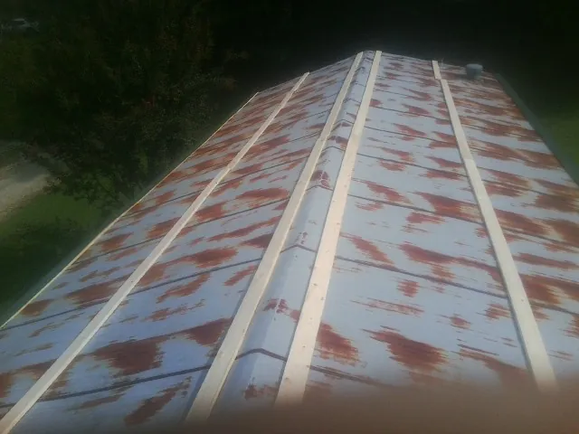 Rusted metal roof panels with new wood purlins before replacement — Storm Damage Roof Repair in Humboldt by Roofing Brothers