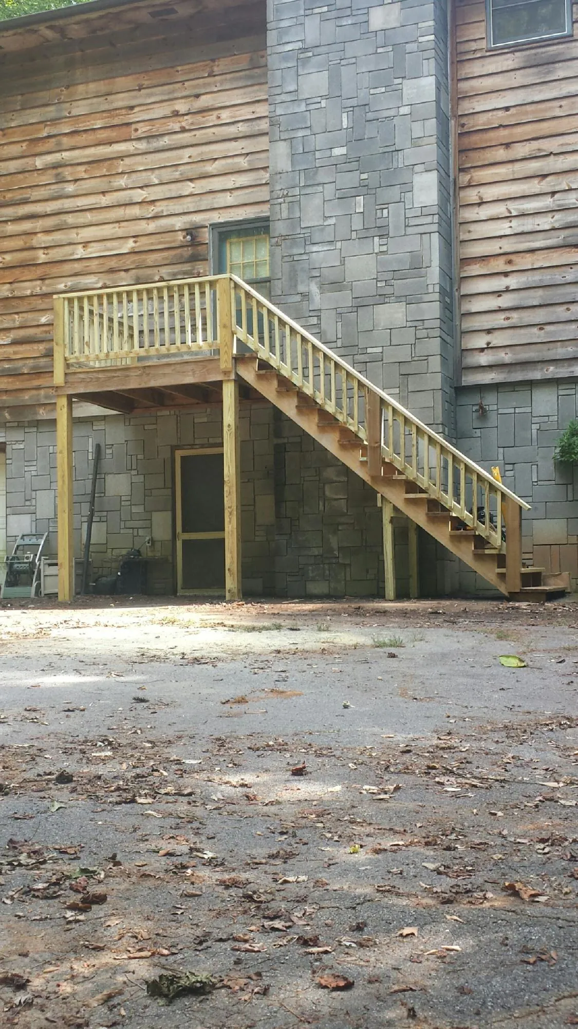 New pressure treated deck and stair landing on a log home in Humboldt